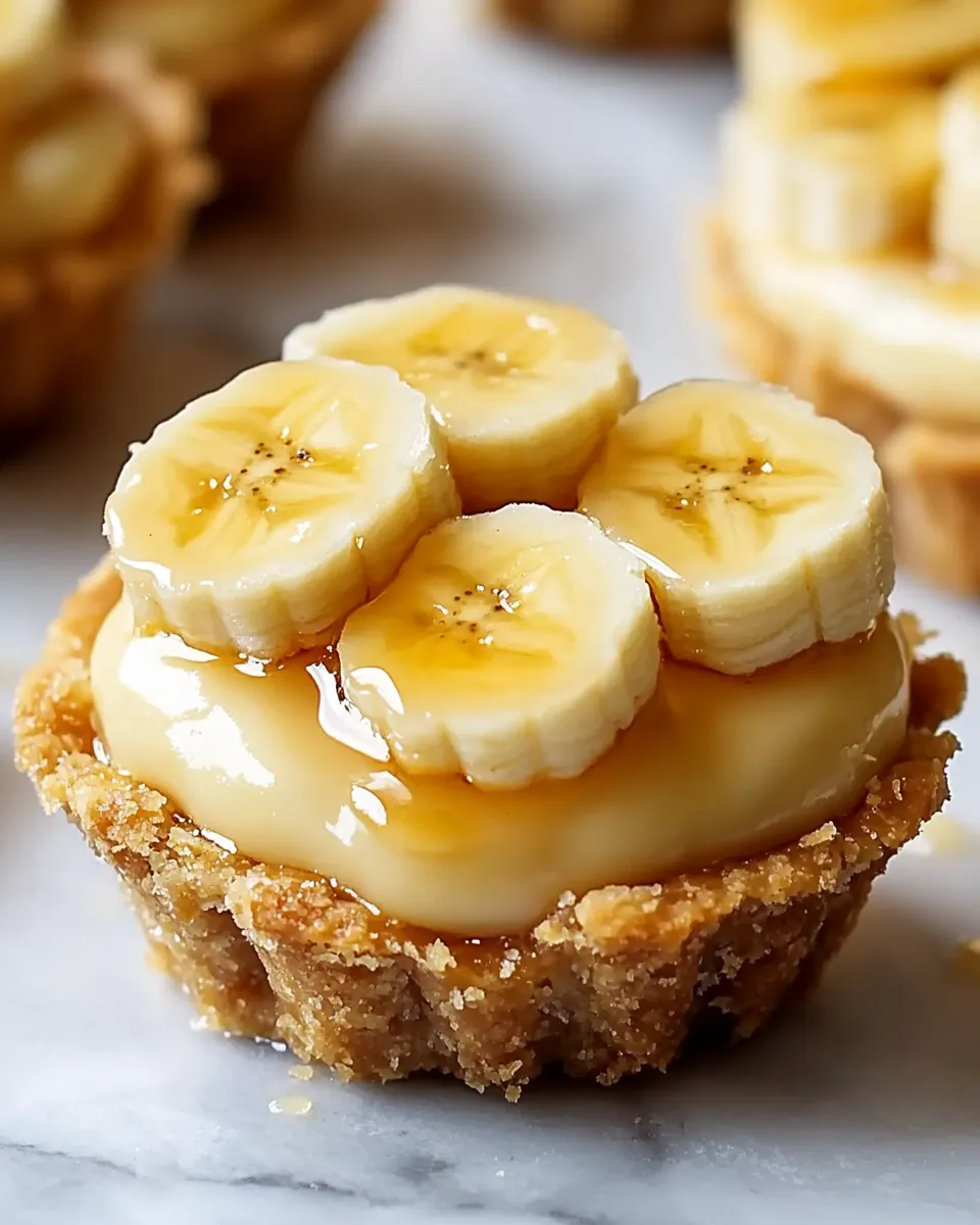 A close up of a dessert with bananas and cream.