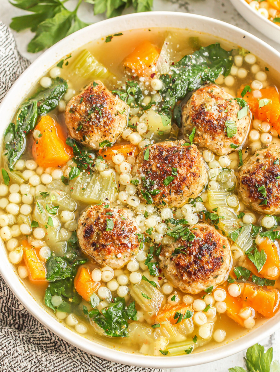 A bowl of soup with meatballs and vegetables.