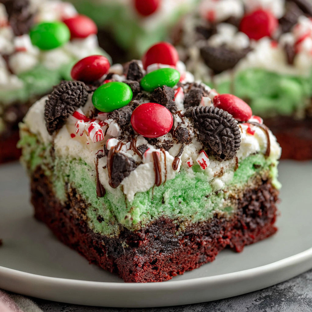 A slice of red velvet cake with chocolate and green and red sprinkles.