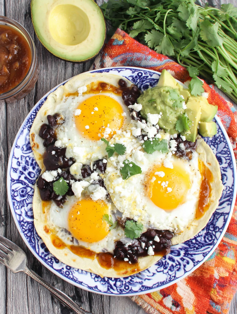 A plate of food with eggs, beans, and avocado.