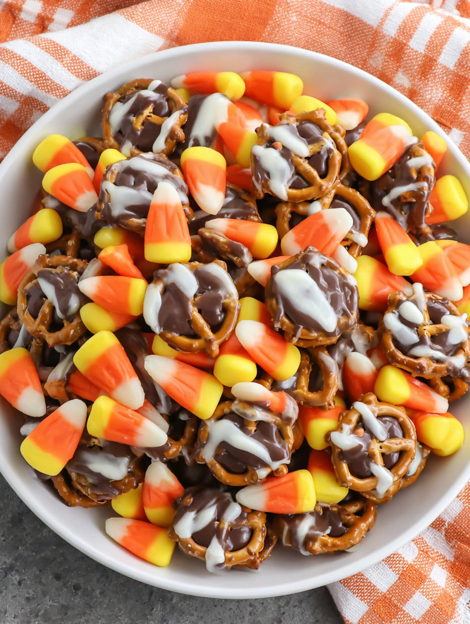 A bowl of candy corn and pretzels.