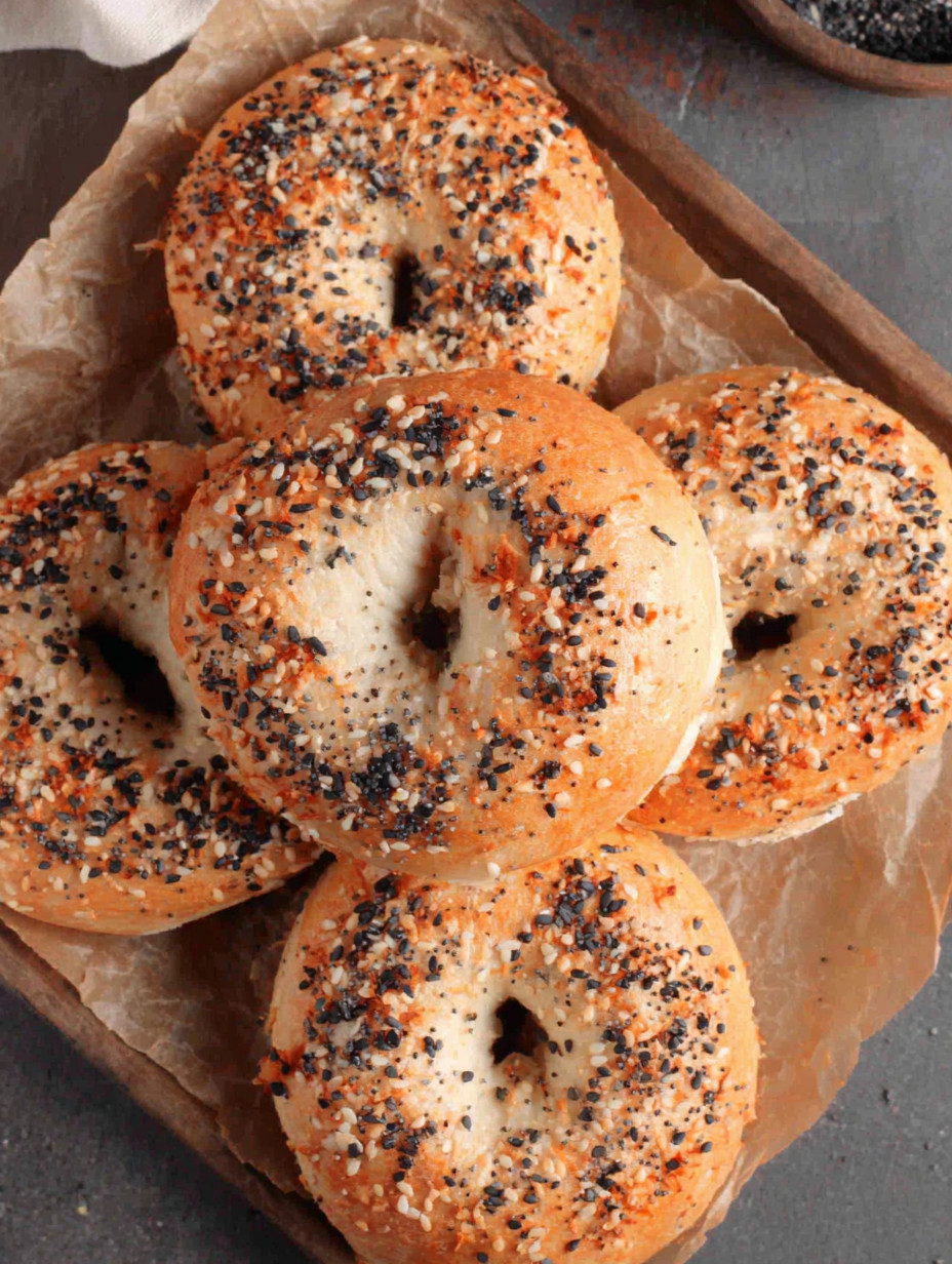 A plate of bagels with sesame seeds.