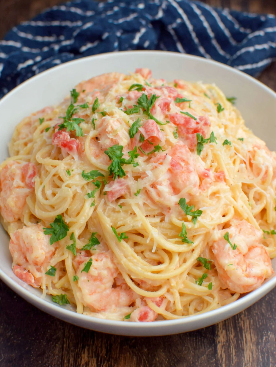 A bowl of spaghetti with shrimp and herbs.