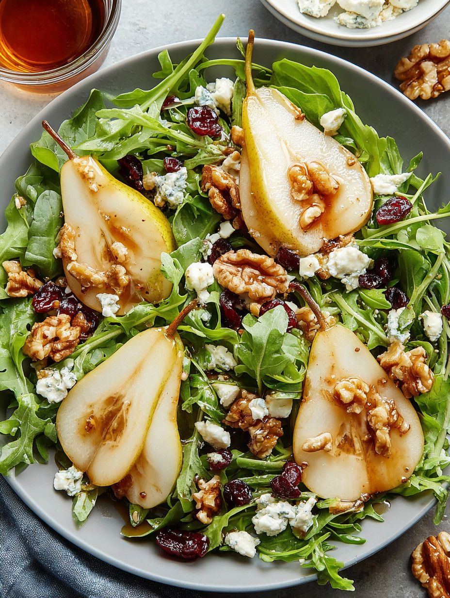 A plate of salad with pears, walnuts, and blue cheese.
