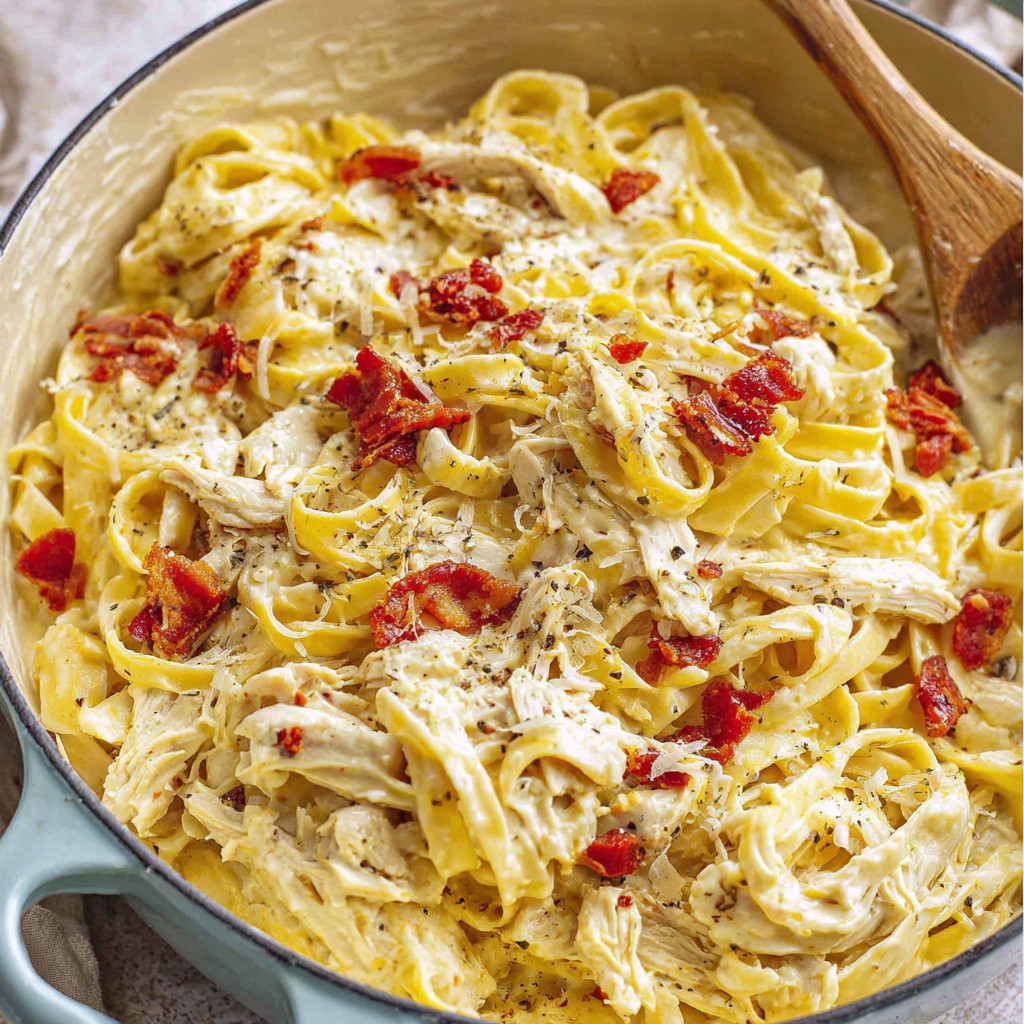 A bowl of pasta with chicken and red peppers.