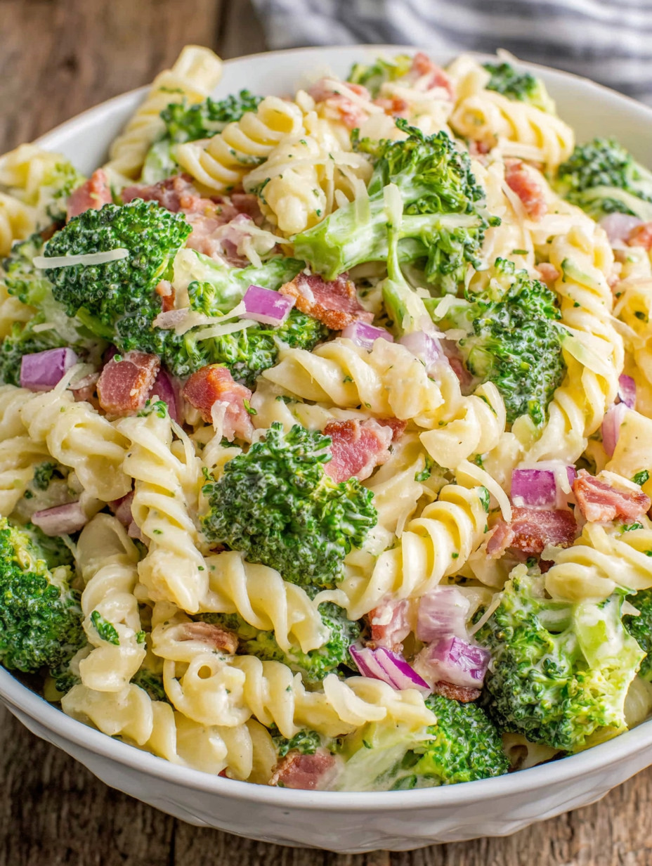 A bowl of pasta with broccoli and ham.