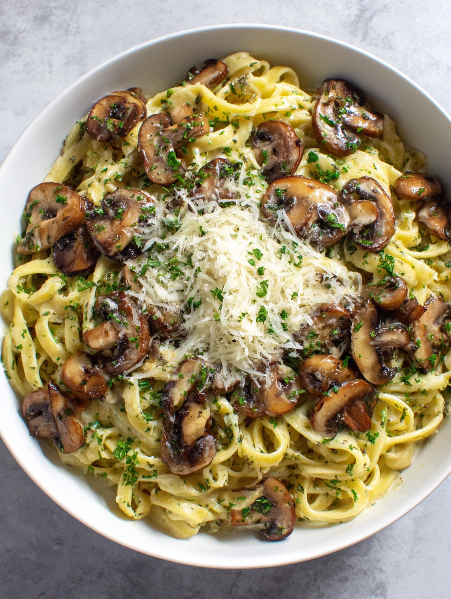 A bowl of pasta with mushrooms and cheese.