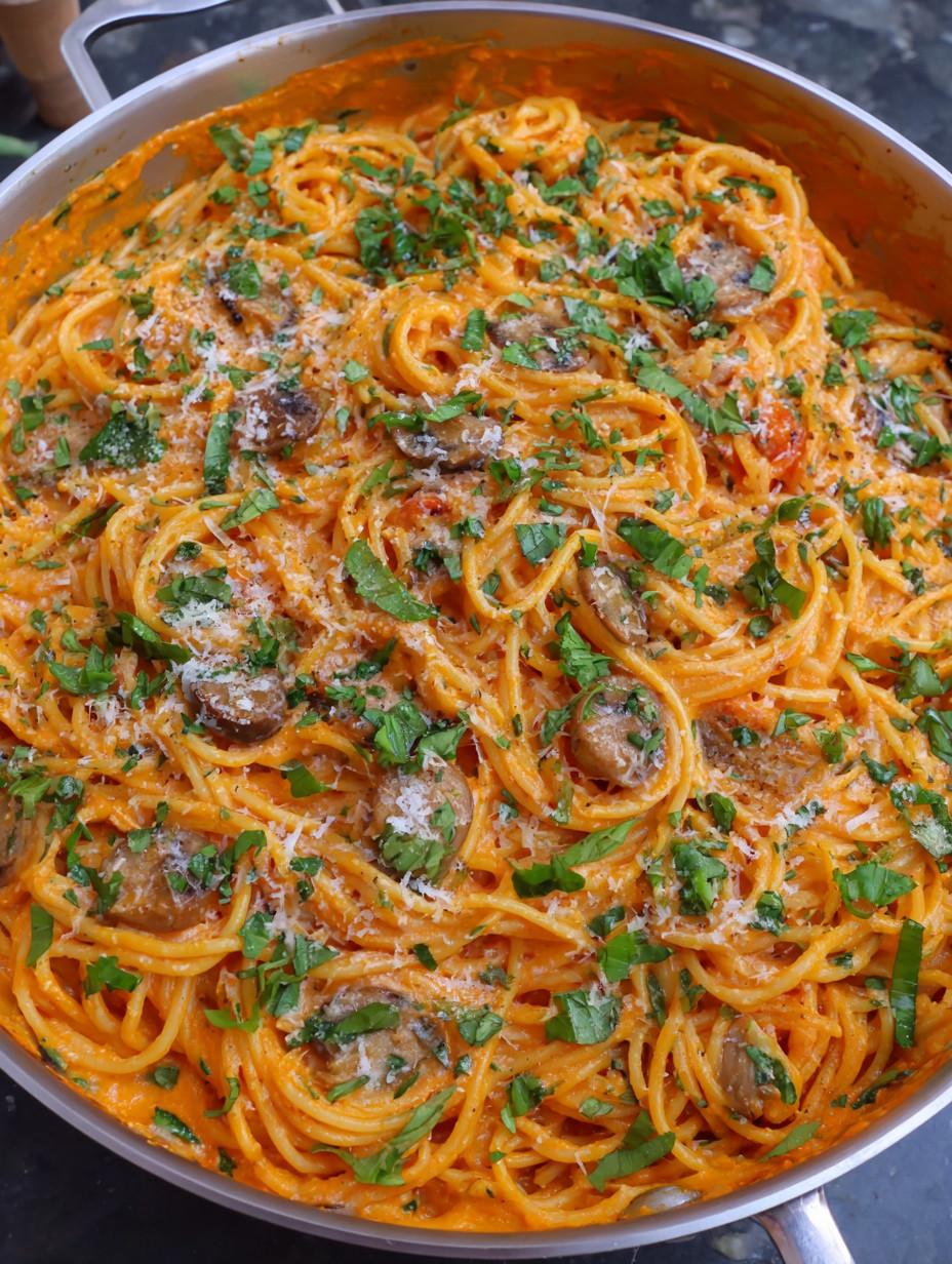 A bowl of spaghetti with mushrooms and herbs.