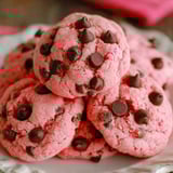 A stack of pink cookies with chocolate chips.