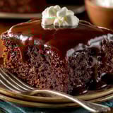 A chocolate cake with white frosting on a plate.