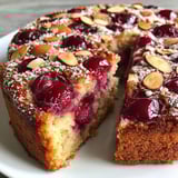 A slice of cake with nuts on top.